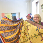 Allinda Maxon, Peggy Savage and Carolyn Miller shows the quilts that were donated to Community Action on Wednesday.